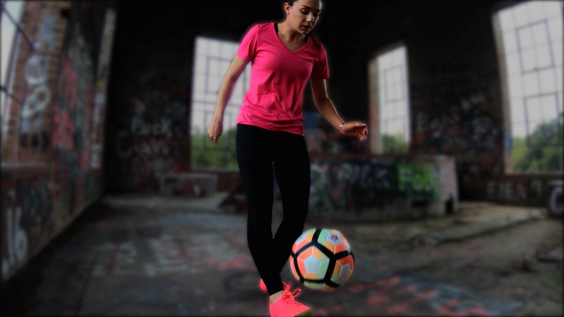 A girl juggles a soccer ball.